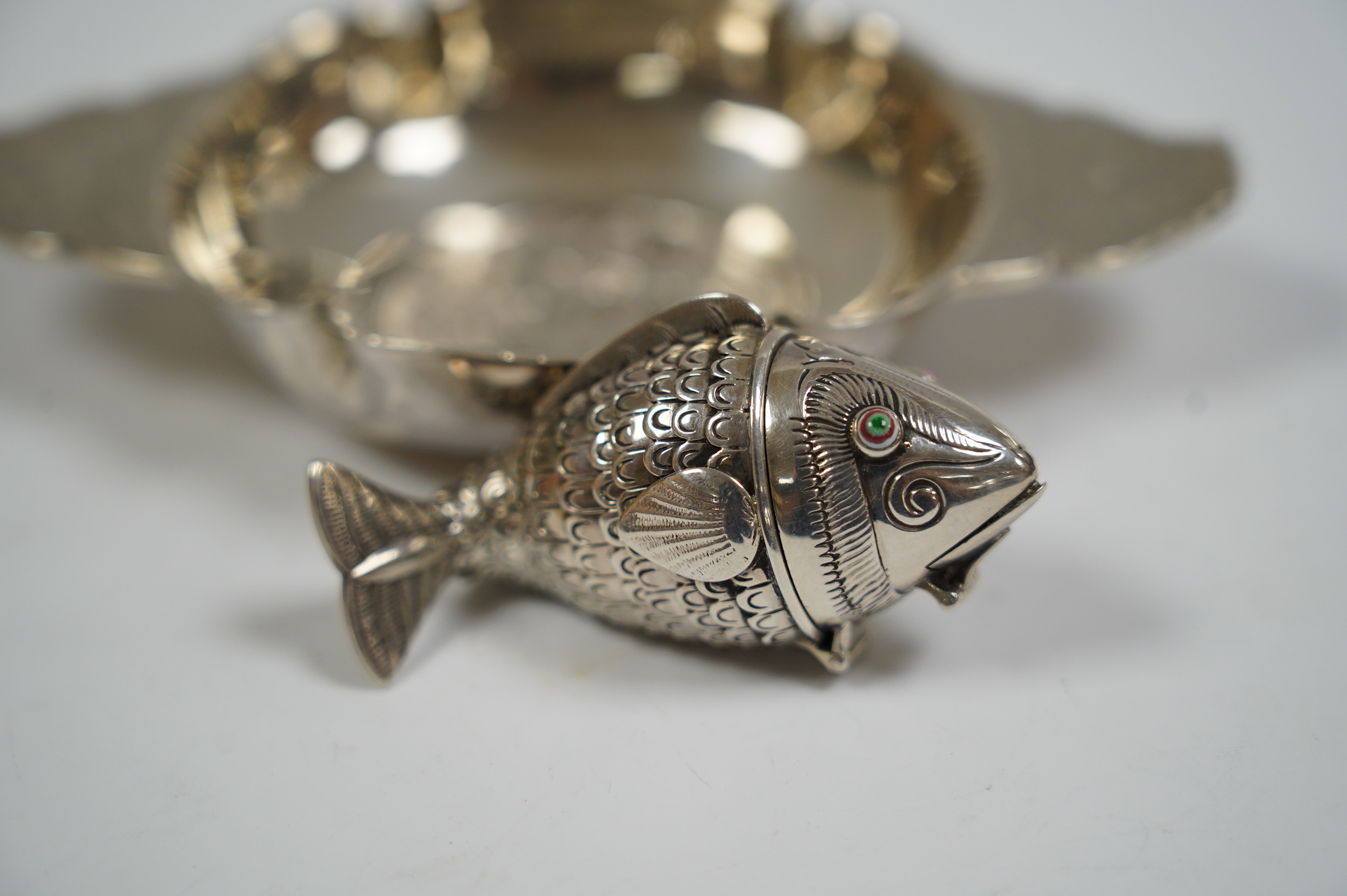 A George V foliate engraved silver quaich by Robert Edgar Stone, London, 1936, 12.2cm, together with a Norwegian 830 standard white metal articulated fish pill box, 60mm. Condition - fair to good